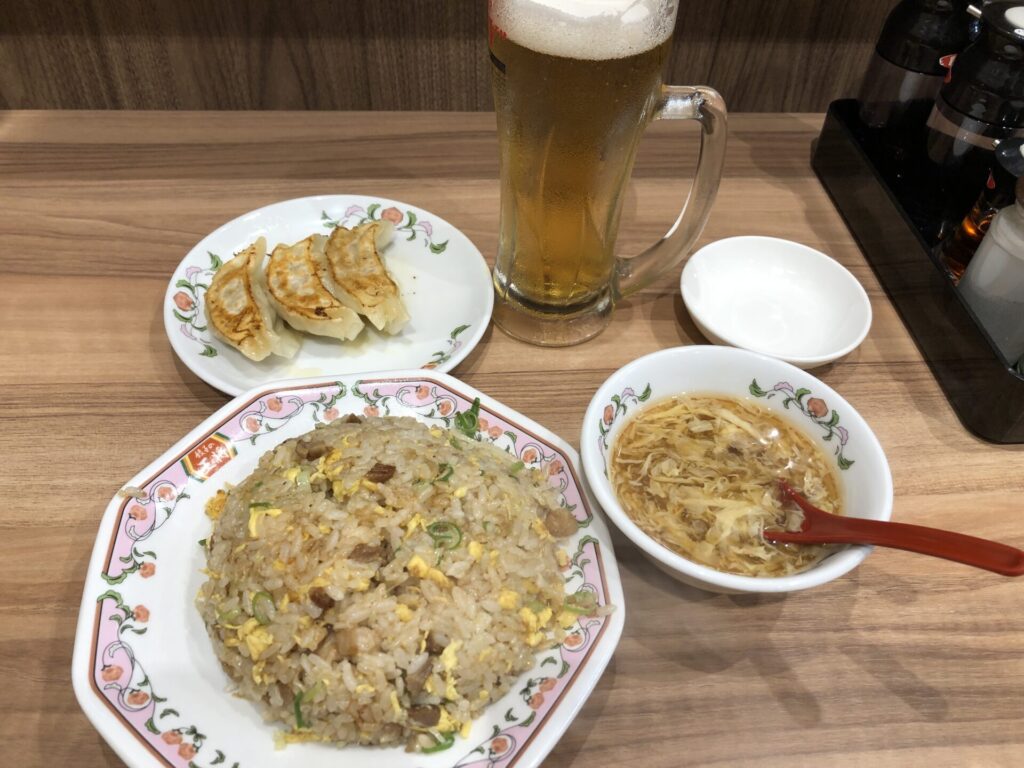 餃子の王将のカウンター席に置かれた、生ビール、チャーハン、にんにく激増し餃子