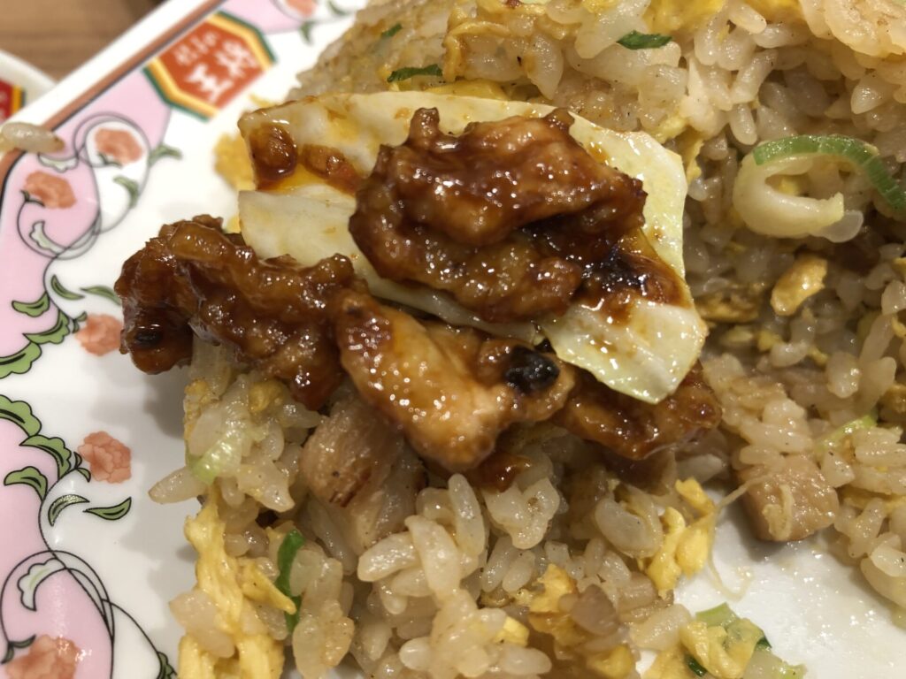 餃子の王将のチャーハンの上に、ジャストサイズの回鍋肉をのせた画像。